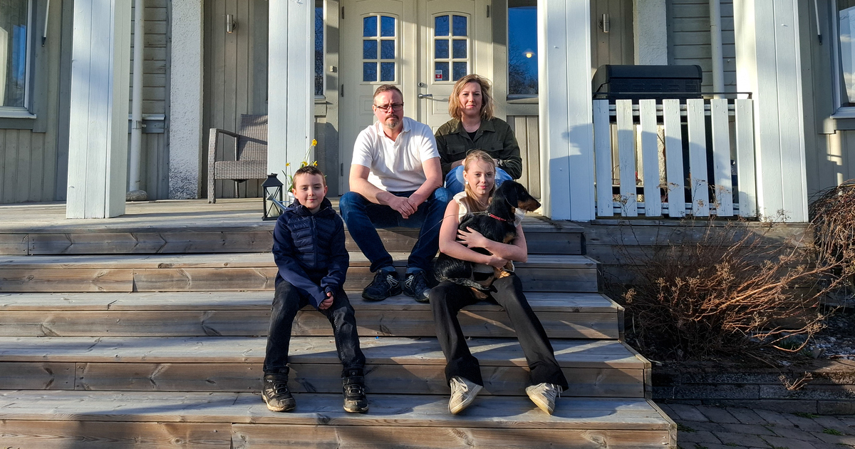 Familjen sitter på trappan framför sitt hus. 