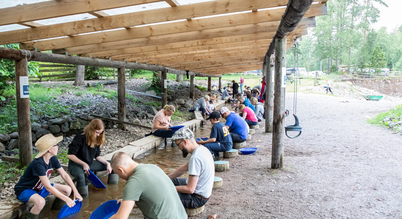 En grupp människor som sitter på en bänk i en park.