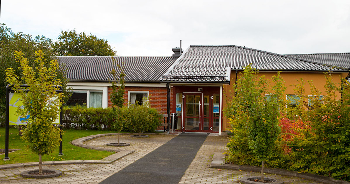 En tegelbyggnad med en gångväg som leder fram till den.