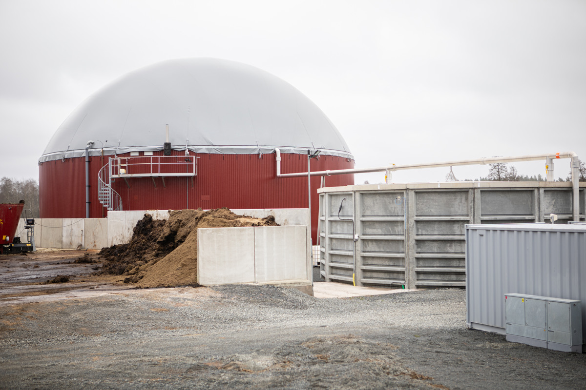 En stor kupolliknande byggnad intill en stor gödselstack på en gård.