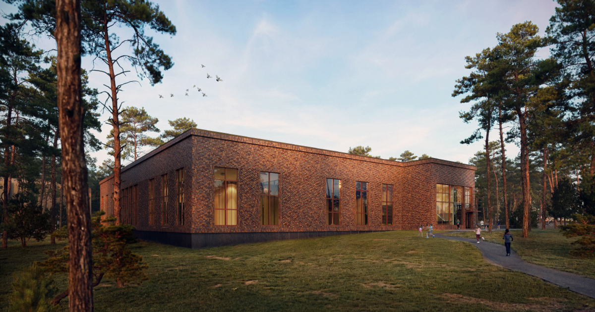 Tegelbyggnad i rött tegel med stora fönster omgiven av tallskog.