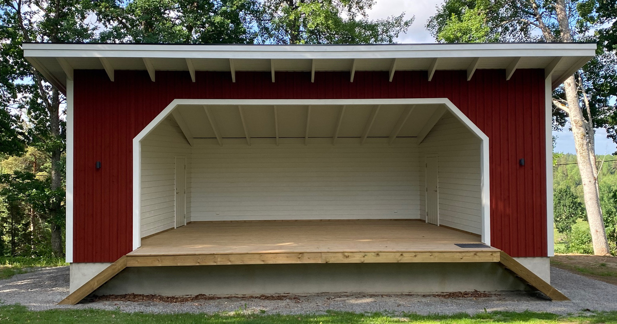 Utomhusscen i trä, rödmålad med vita snickerier.