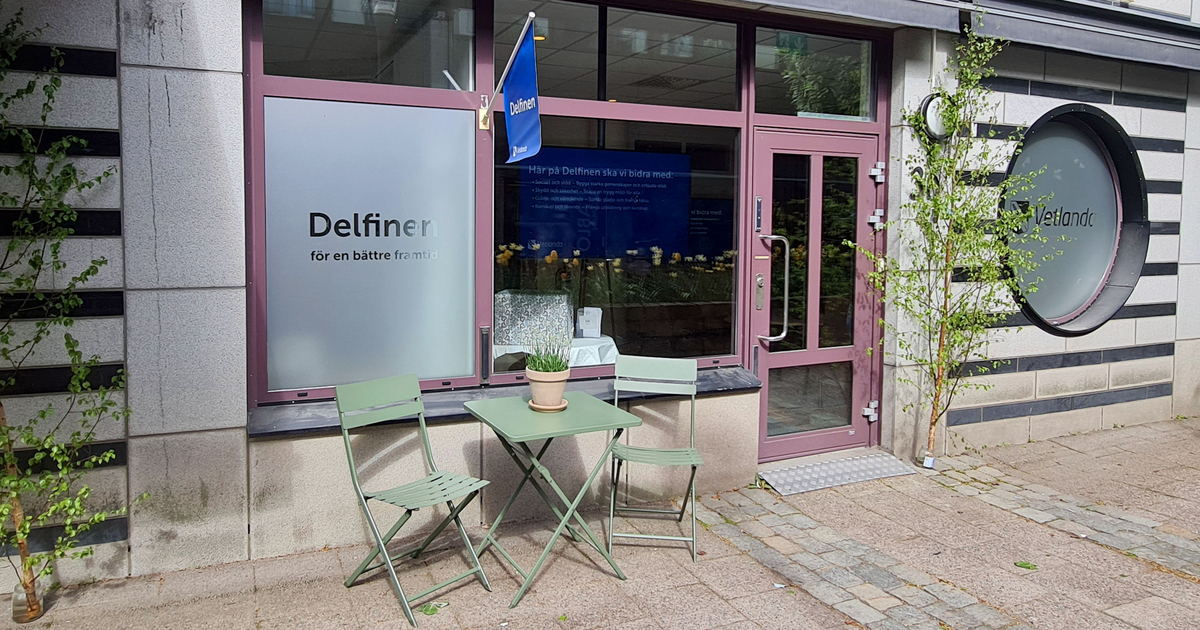 Entrén till Delfinen på bilden. Med balkongmöbler utanför, två stolar och ett bord.