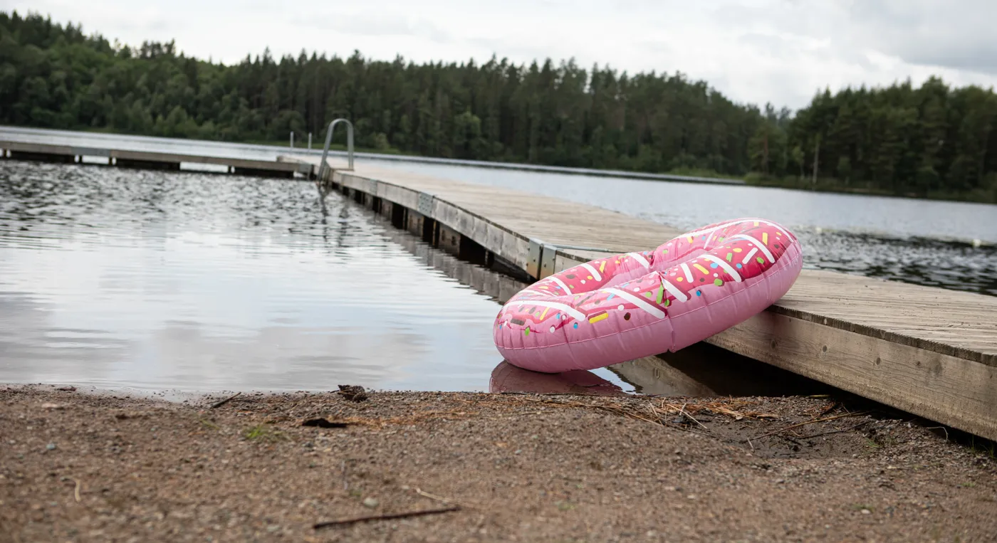 En rosa flotte som ligger på en träbrygga intill bryggan, Lammåsabadet.