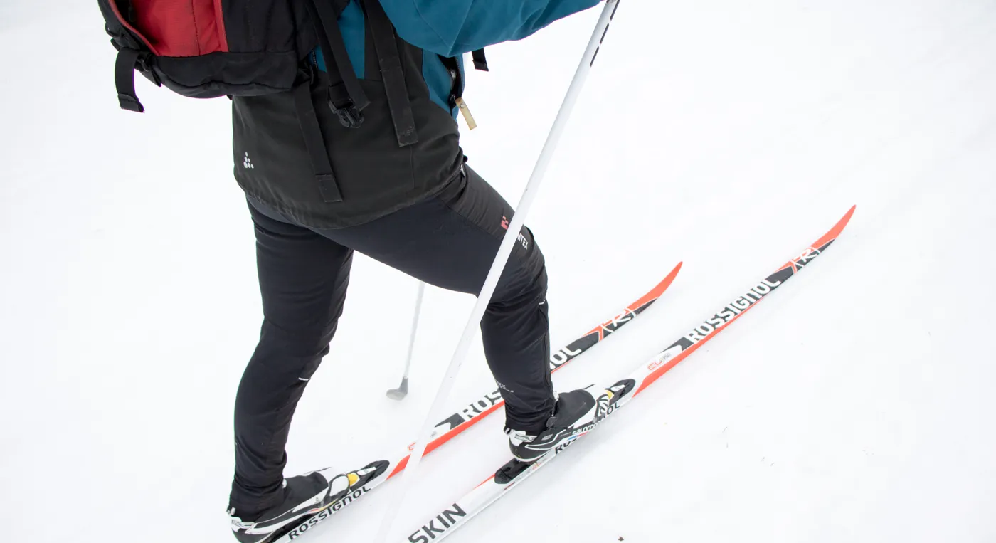 En person på skidor med en ryggsäck på ryggen.