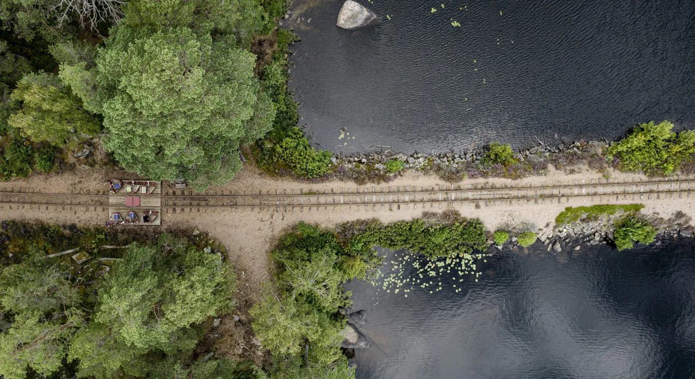 En flygbild över en tågräls vid en sjö