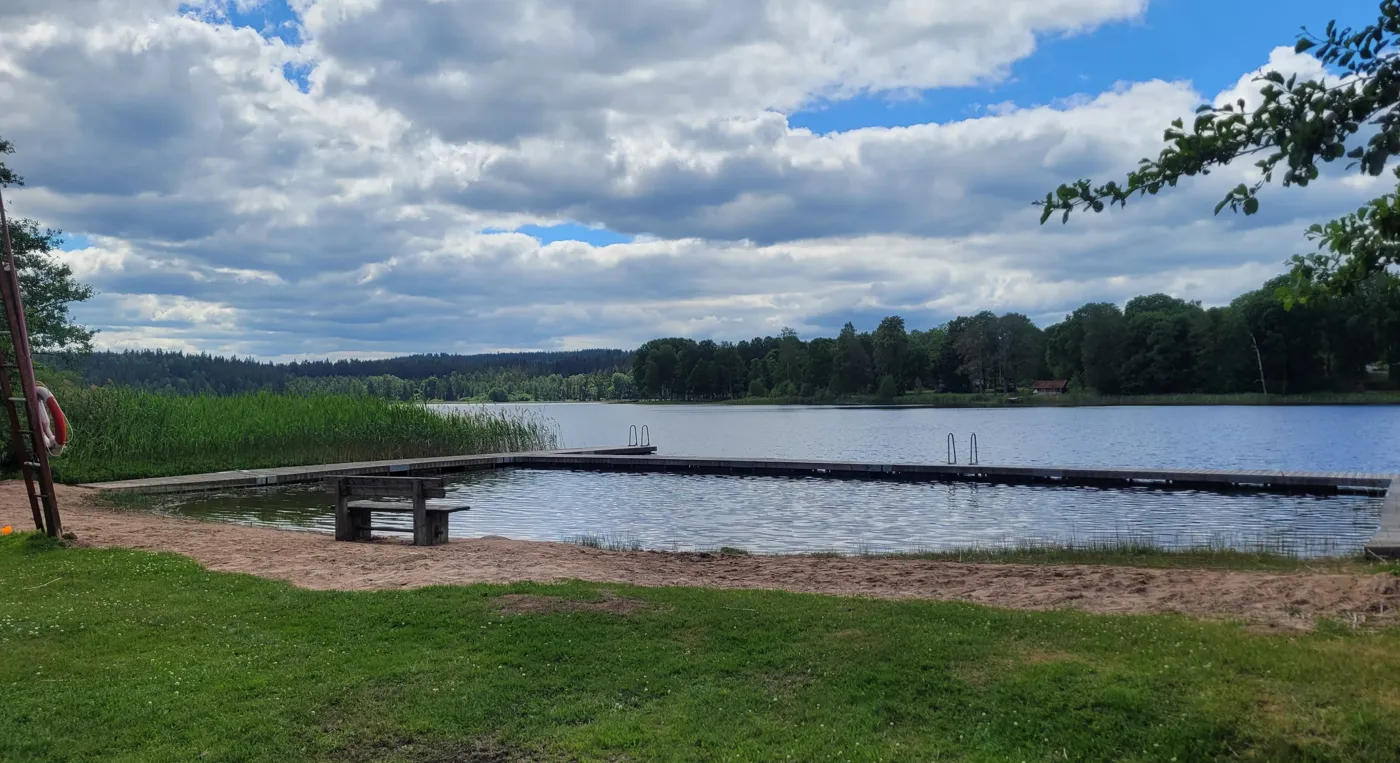 Ett picknickbord som står vid stranden av en sjö.