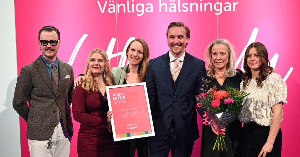 Sex personer står uppställda vid en fotovägg och ler. Tillsammans håller de i ett diplom och en blombukett.