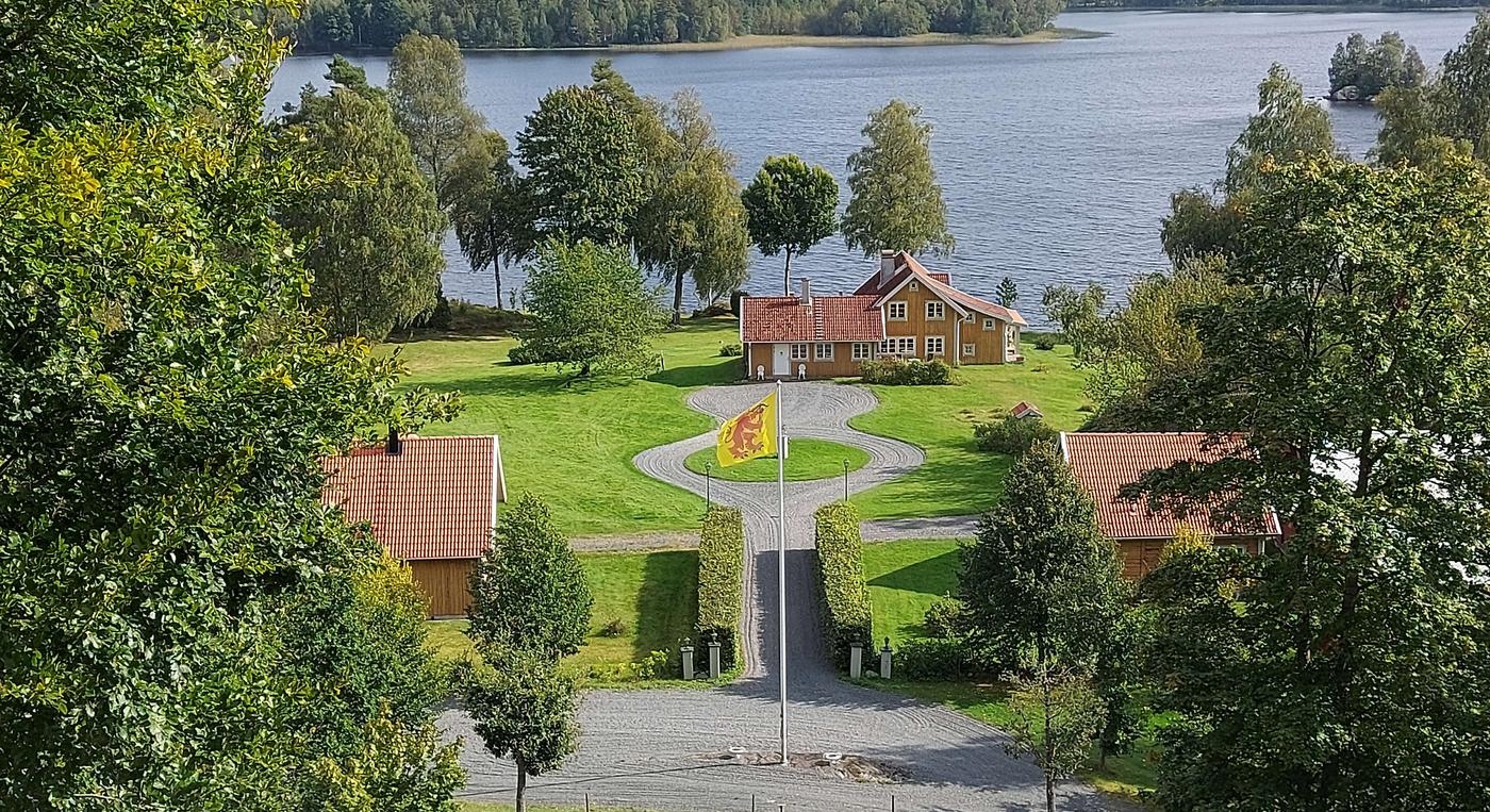 Vacker sommarvy över anläggningen med sjön i bakgrunden.